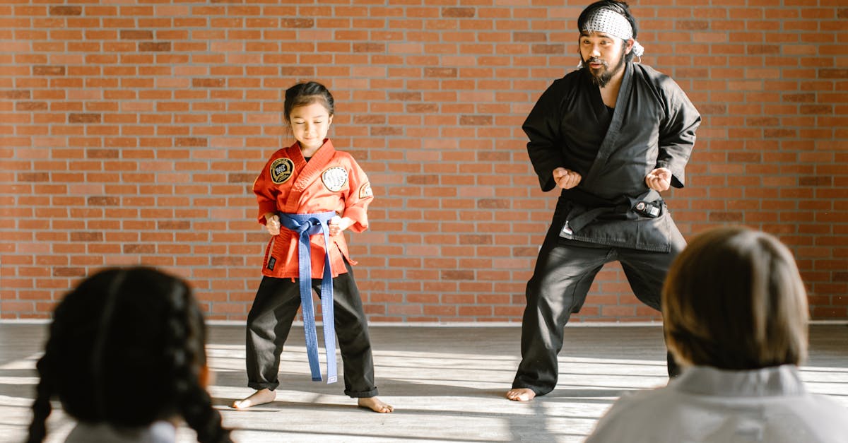 A martial arts instructor and a child student practicing karate in a dojo.